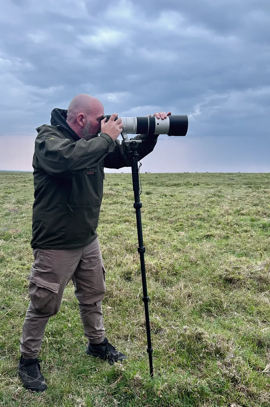 Alan on the Lemek Conservancy savanna with his Fujifilm X-H2S and XF150-600mm on 3 Legged Thing Alana monopod and AirHed Trinity.